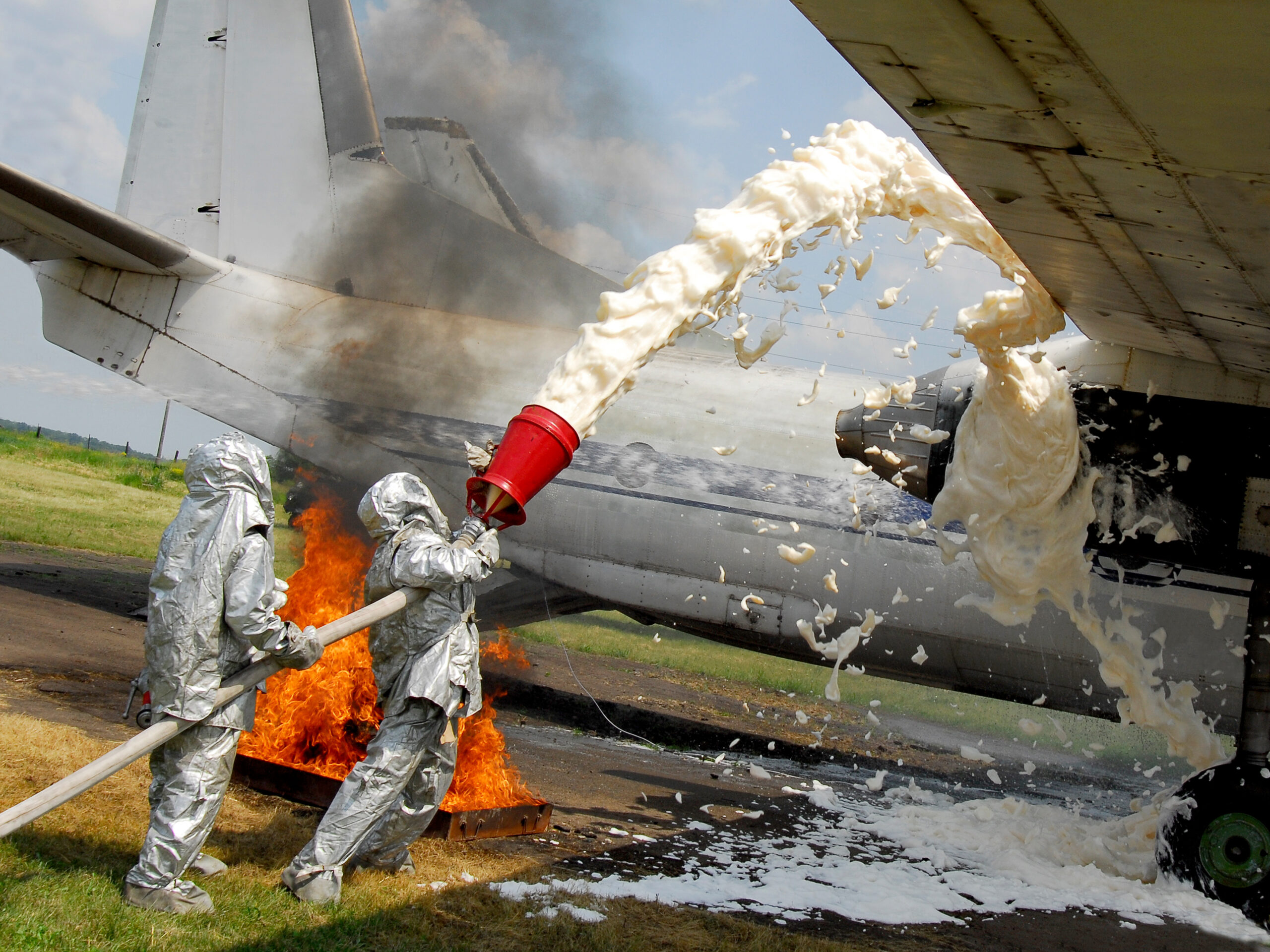 firefighters utilize aqueous fire fighting foam to suppress a burning jet engine