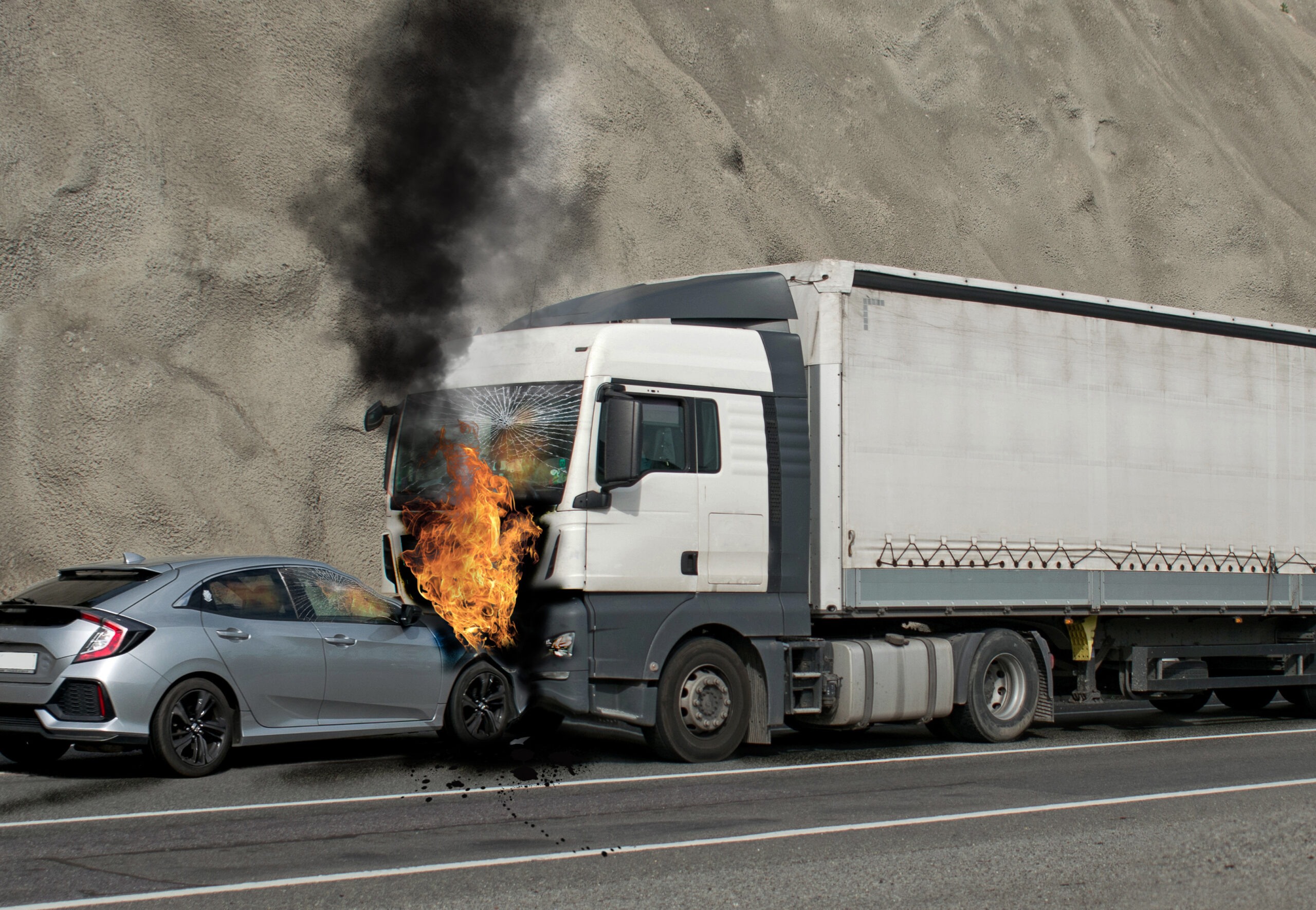Collision between a car and a truck transporting goods. Accident followed by fire. The car caught fire after the frontal impact.