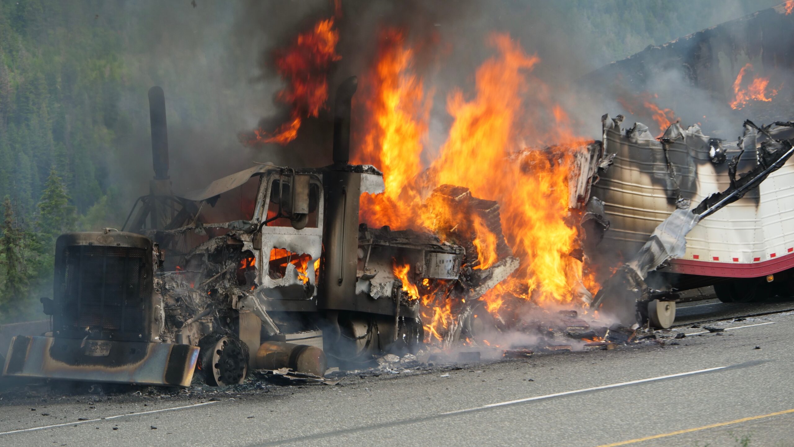 A semi truck burns out of control on a highway