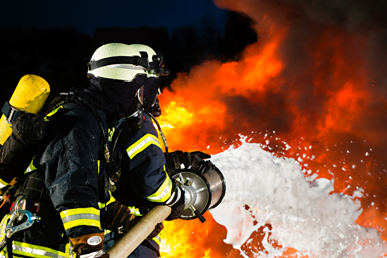 firefighters using foam to stop a fire